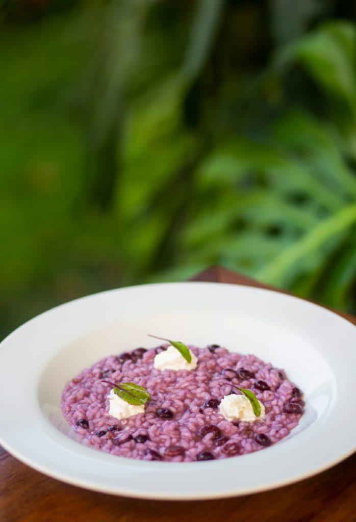 Prato branco com um risoto de coloração rosada.