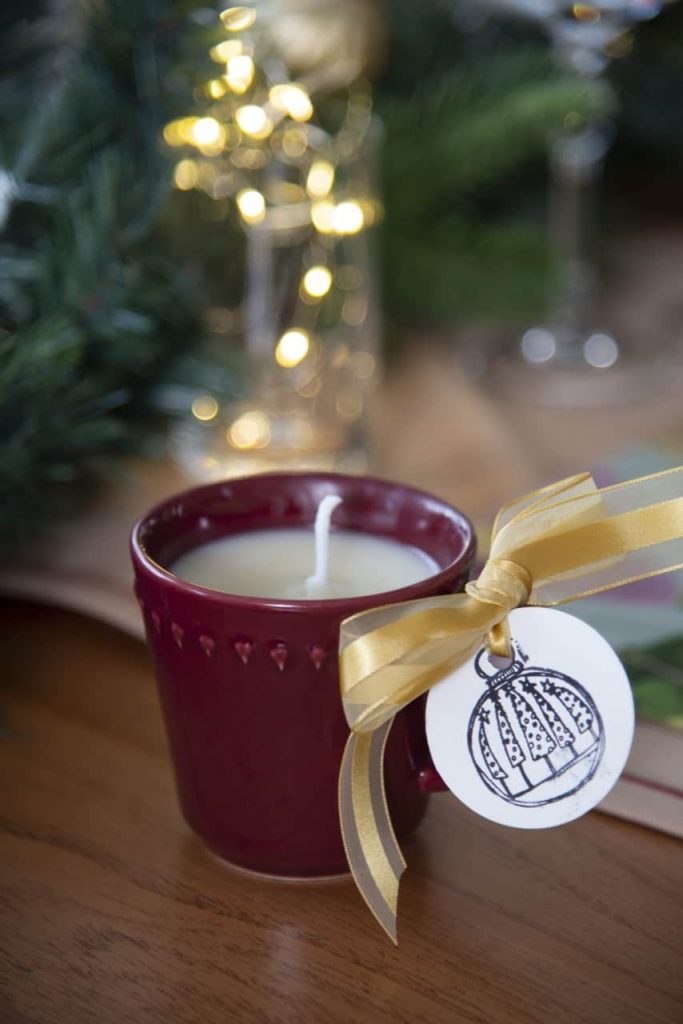 Detalhe da mesa posta de Natal: vela feita dentro da xícara de porcelana vinho.