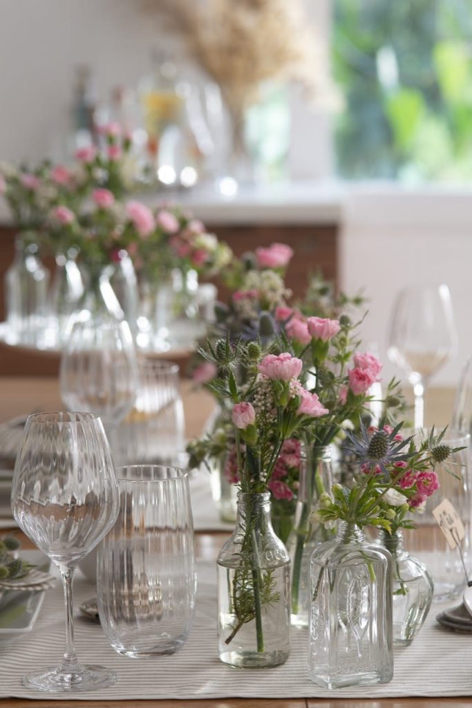 Taças, copos e garrafas com flores.