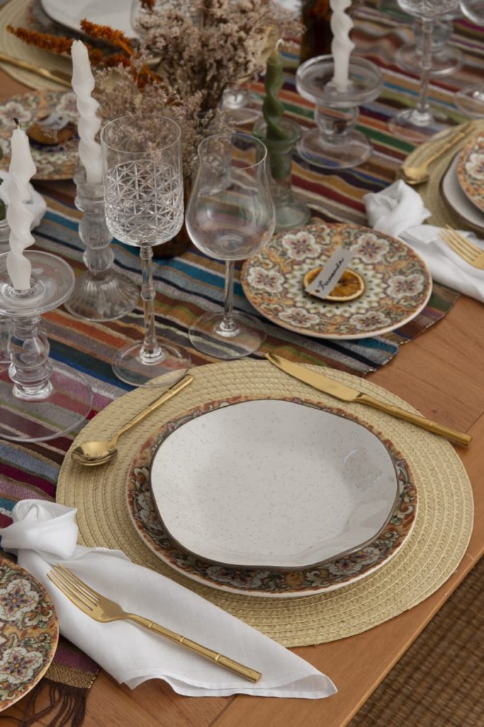 Um lugar na mesa posta para o almoço marroquino, com porcelanas finas e taças de cristal