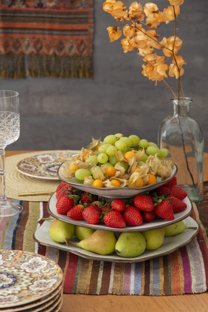 Prato de três andares com pêras, morangos, uvas e physalis (camapu).