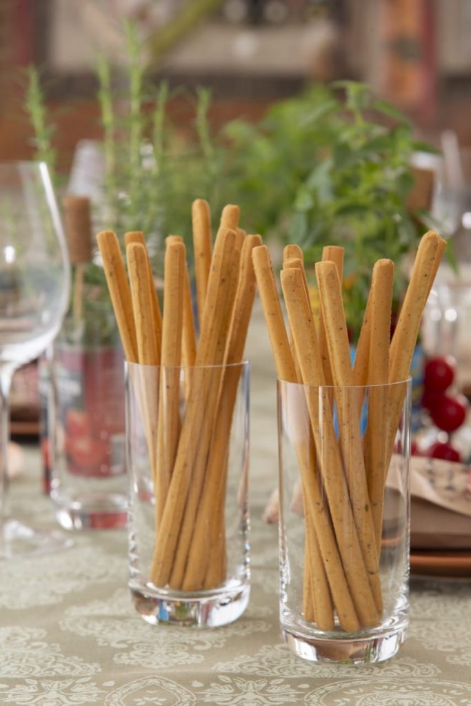 Dois copos com grissini. palitos de pão sempre servidos como aperitivo em um almoço italiano.