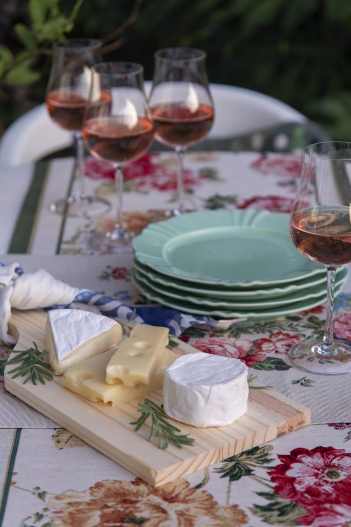 Na mesa posta francesa, temos uma tábua de madeira com três tipos de queijo: brie, camenbert e suíço. 