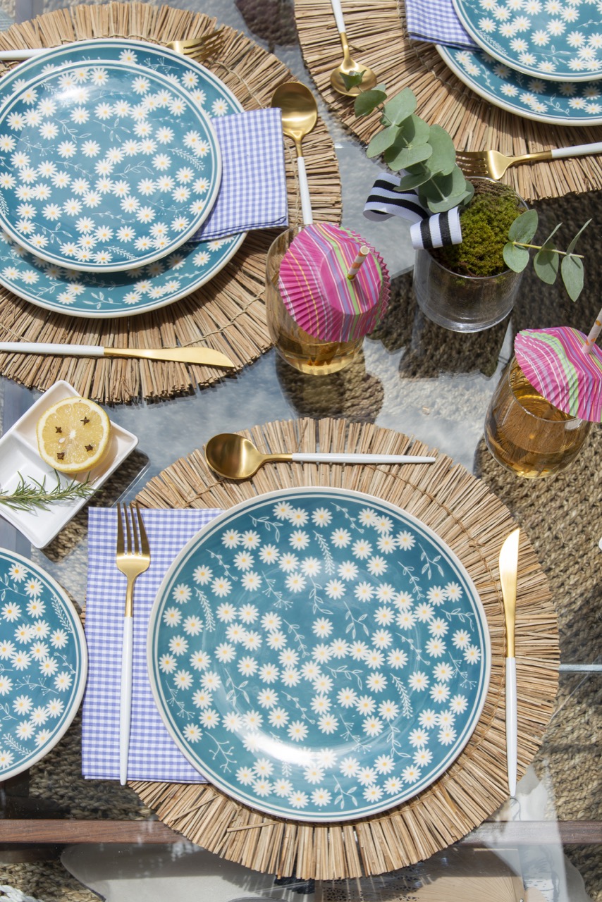 Foto aproximada mostra as louças com fundo azul e estampa de margaridas brancas. 