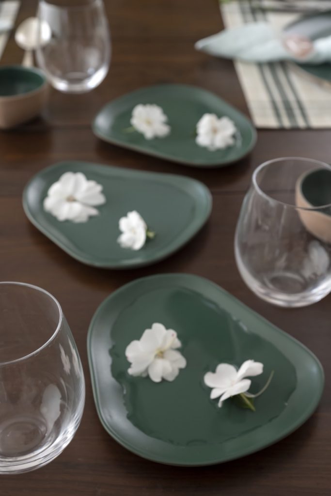 Três pratos com água e flores brancas.