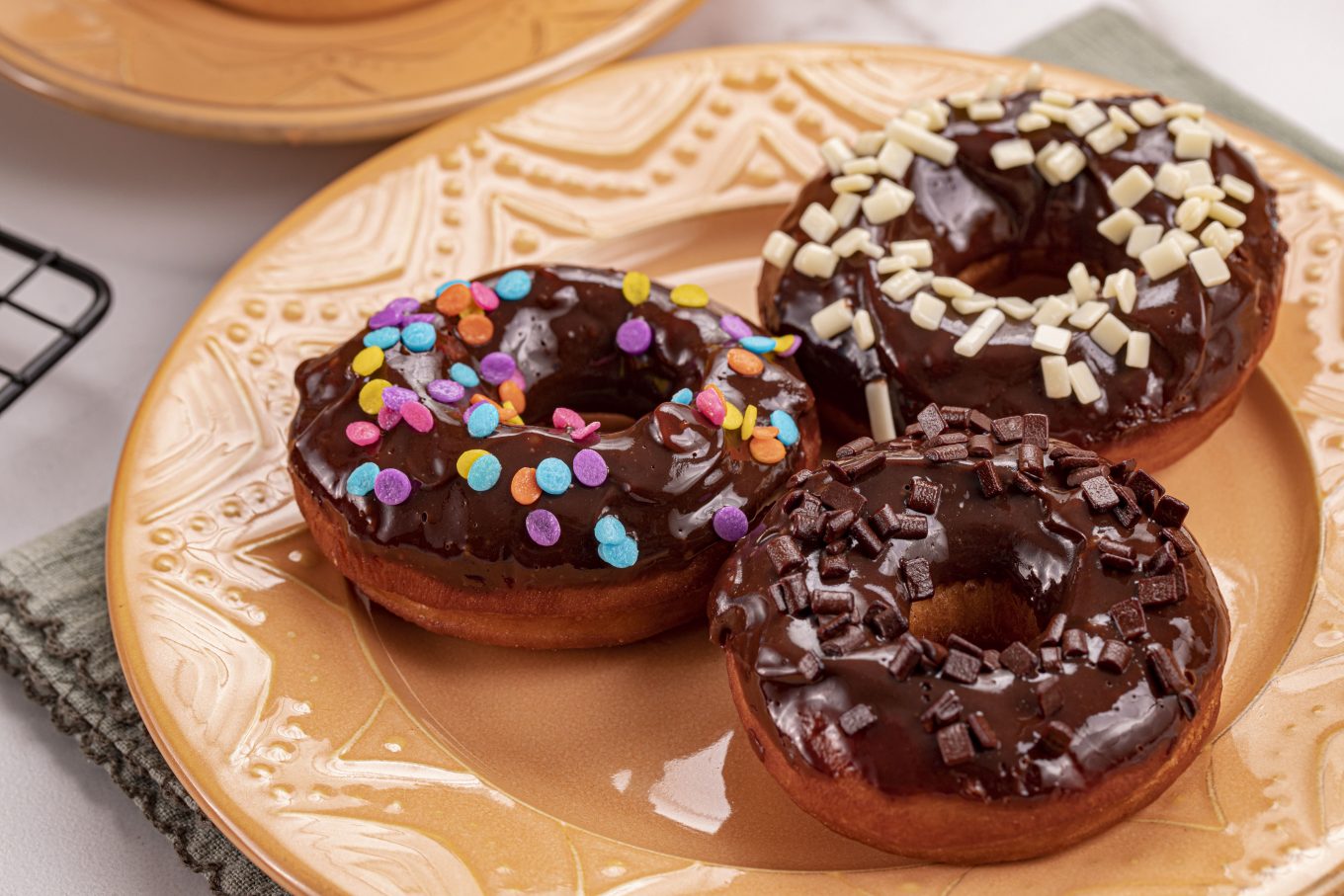 Imagem: donuts coloridos servidos em prato laranja