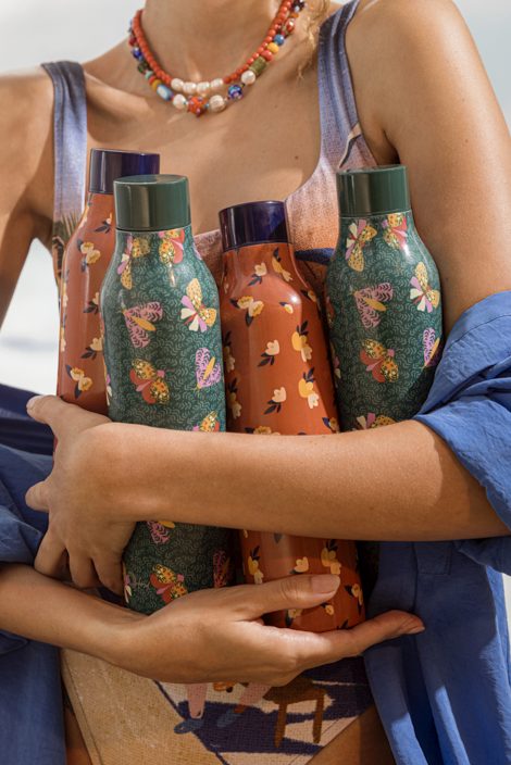 Imagem: garota segurando garrafas térmicas.