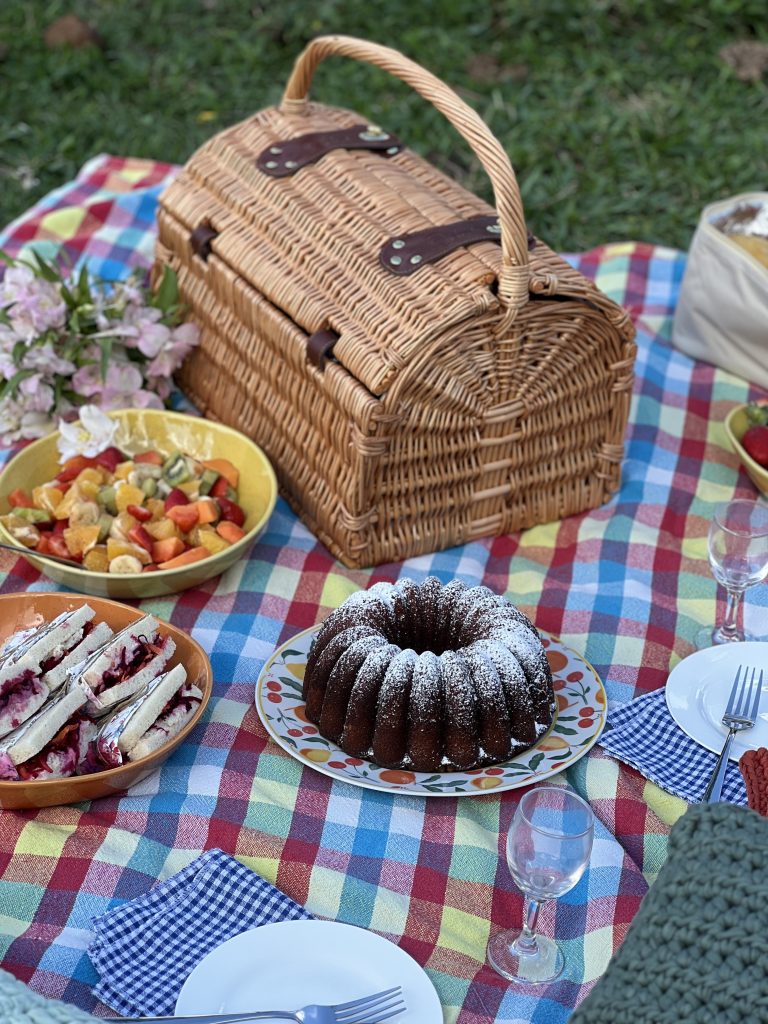 Imagem: cesta de piquenique em toalha xadrez.