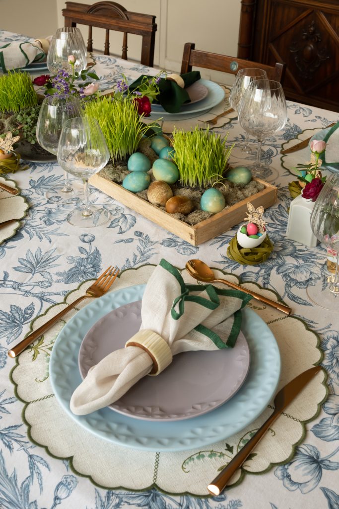 Imagem: mesa posta de Páscoa com pratos azul claro e lilás. 