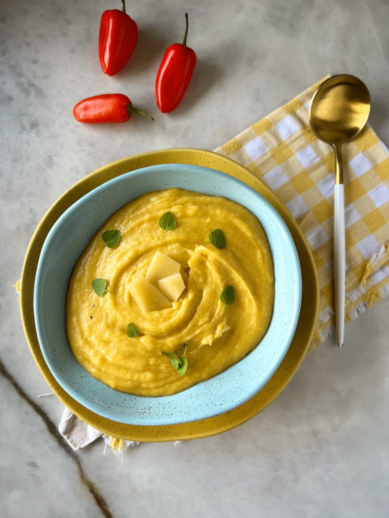 Imagem: purê de mandioquinha servido em bowl azul dentro de bowl amarelo.