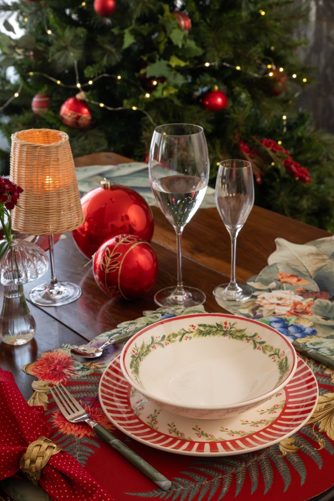 Imagem: mesa com louça de Natal em mesa decorada com bolas natalinas.