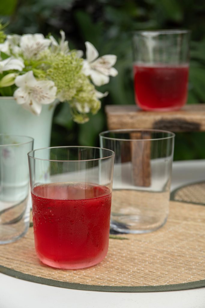 Imagem: copo de cristal transparente da Oxford servido com suco vermelho. 