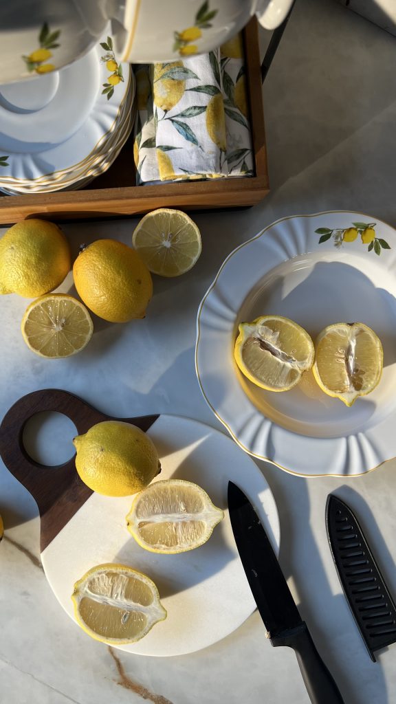 Imagem: mode de preparo de mousse de limão com limões cortados ao meio sobre tábua de mármore da Oxford e prato da coleção Soleil Limoni.